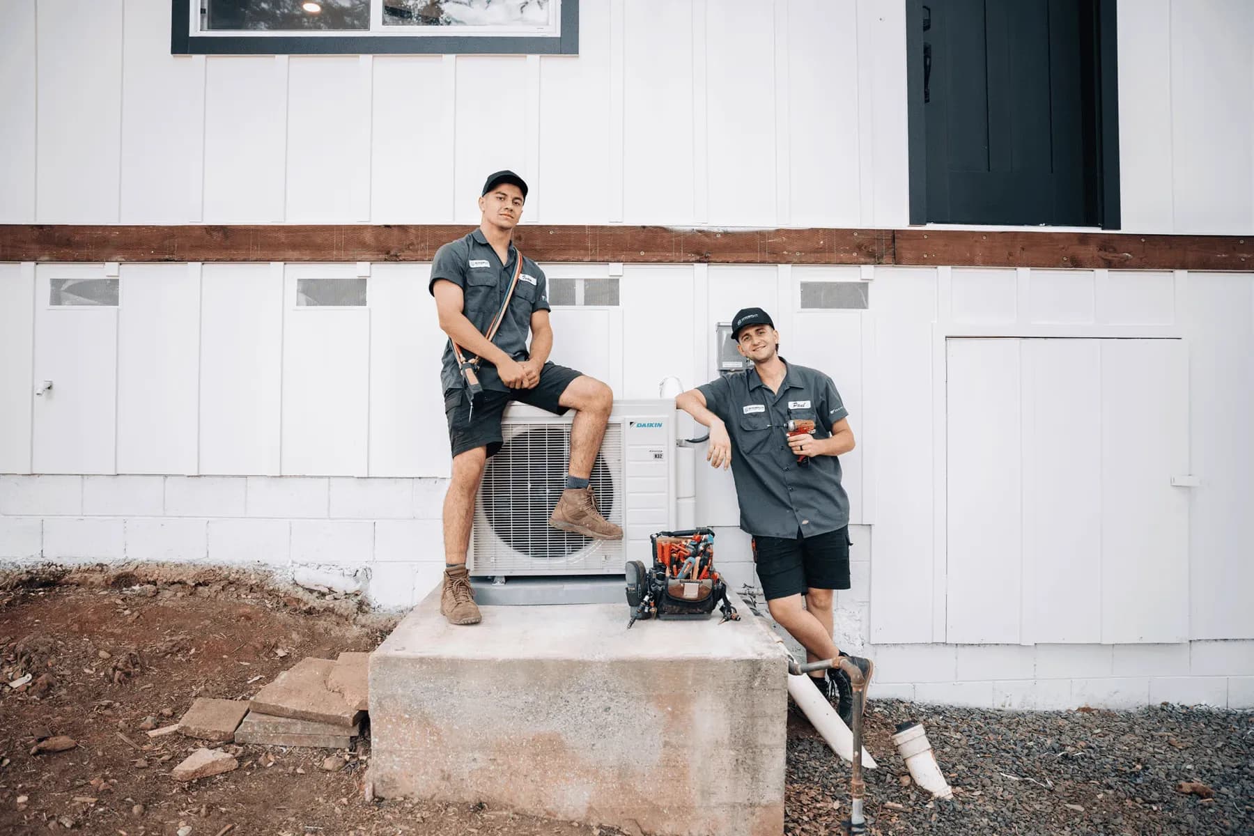 Two Mini Split Experts technicians beside an outdoor unit